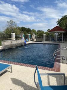 a large swimming pool with a blue chair in it at La Quinta by Wyndham Rosenberg in Rosenberg