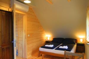 sypialnia z łóżkiem z drewnianą ścianą w obiekcie Chata Zimnik, ruska bania w Szczyrku