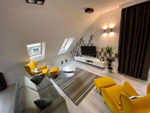 a living room with a couch and yellow chairs at Ski Sun Sea - Rodzinny apartament pod gondolą in Świeradów-Zdrój