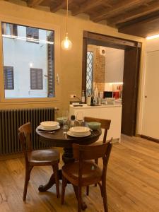 uma sala de jantar com mesa e cadeiras e uma cozinha em AI MAGAZZINI DEI MEDICI (casa con balcone) em Florença