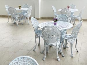a group of white tables and chairs with flowers on them at HOTEL GRAND BOUTIQUE in Fusagasuga