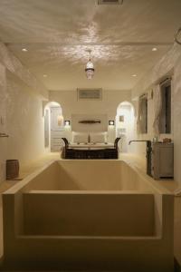 uma grande banheira branca num quarto com uma cama em Riad Lamp em Nanjo