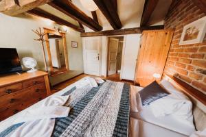 a bedroom with a bed and a brick wall at Hotel U Hrabenky in Telč