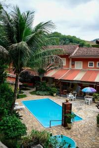 a swimming pool in front of a house at Pousada Solmaior in Conservatória