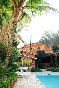 Un complejo con una palmera y una piscina. en Pousada Solmaior, en Conservatória