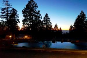 a sunset over a pond in a yard with trees at The Lodge at Cloudcroft in Cloudcroft