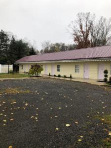 a white building with a parking lot in front of it at Oakes Oramel Inn in Oramel