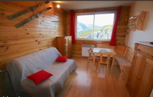 a bedroom with a bed and a table and a window at Appartement - cœur de station in Enchastrayes