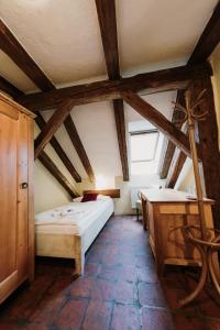 a bedroom with a bed and a desk in a attic at Hotel U Hrabenky in Telč