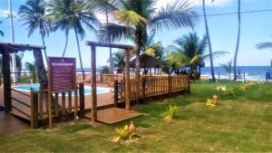 un complejo con piscina, palmeras y un cartel en Pousada Canto dos Encantos, en Barra Grande