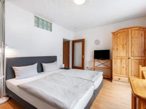 1 dormitorio con 1 cama grande y armario de madera en Nice studio near Luxembourg, en Bollendorf