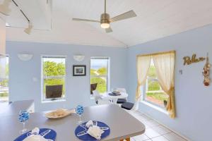 uma sala de jantar com paredes azuis e uma ventoinha de tecto em Binnie’s Beachfront Bungalow em Clearwater Beach