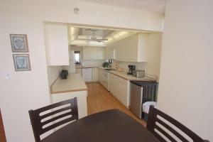 a kitchen with white cabinets and a table and chairs at 1208 Lighthouse Towers in Clearwater Beach