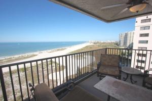 a balcony with a view of the beach and a chair at 1208 Lighthouse Towers in Clearwater Beach