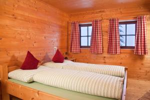 two beds in a log cabin with windows at Appartement Rossalm mit Sauna in Alpbach