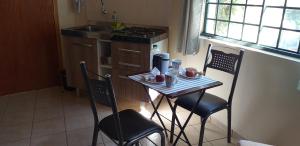 a small kitchen with a table and two chairs at Chalé e Camping Daragona 2 in Águas de Lindóia