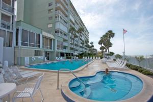 a swimming pool with chairs and a building at 707 Sandcastle One in Clearwater Beach