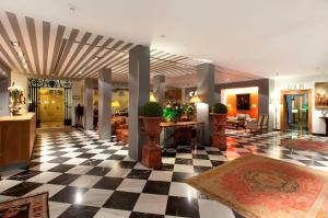 un vestíbulo con suelo a cuadros en un hotel en Hotel Doña María en Sevilla