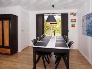 a dining room with a black table and chairs at 8 person holiday home in Hemmet in Falen