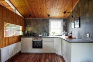 een keuken met witte apparatuur en een houten plafond bij SCHWANENNEST AM HADDORFER SEE * TOP AUSSTATTUNG in Wettringen