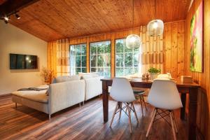 a living room with a table and chairs and a couch at HOMEFY - Schwanennest Am Haddorfer See in Wettringen