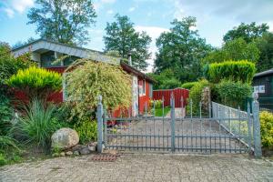 a gate in front of a red house at SCHWANENNEST AM HADDORFER SEE * TOP AUSSTATTUNG in Wettringen