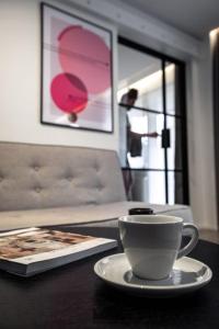 ウッチにあるSienkiewicza 59 Park Apartmentのテーブルと皿の上に座ってコーヒーを飲む