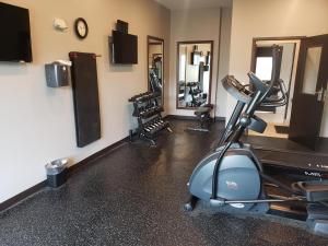 a room with a gym with exercise equipment and mirrors at Wingate by Wyndham Christiansburg in Christiansburg