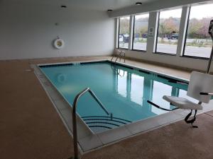 a large swimming pool in a building with a chair at Wingate by Wyndham Christiansburg in Christiansburg