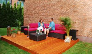 a man and a woman sitting on a pink couch at Privathotel alte mühle Wolfsburg-Weyhausen in Wolfsburg