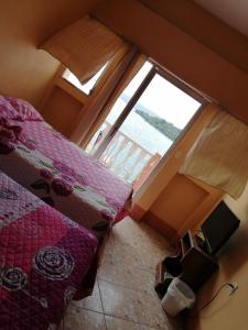sypialnia z łóżkiem i dużym oknem w obiekcie Hotel Aurora w mieście Flores