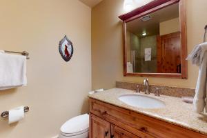 a bathroom with a sink and a toilet and a mirror at Copper Valley 114 in Copper Mountain +31 photos