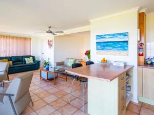 a kitchen and living room with a couch and a table at Alexandra Suite Gerroa in Gerroa