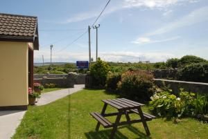 een picknicktafel in het gras naast een huis bij Ard Mhuiris B&B in Inis Mor