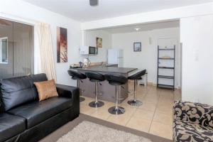a living room with a black couch and a table at Coromandel Seaview Motel in Coromandel Town