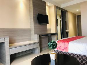 a bedroom with a bed and a tv on a wall at Prime Asia Hotel in Angeles