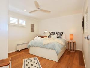 a white bedroom with a bed and a ceiling fan at Jervis Bay Beach Shack I Pet Friendly in Vincentia