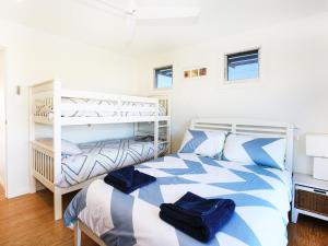 a bedroom with a bed and a bunk bed at The Palings at Culburra I Pet Friendly Masterpiece in Culburra Beach