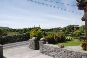 a stone retaining wall with a view of a road at Ard Mhuiris B&B in Inis Mor
