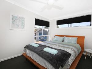 ein Schlafzimmer mit einem Bett mit zwei Kissen darauf in der Unterkunft Tillys Retreat I Pet Friendly I 3 Min Walk to Beach in Culburra Beach
