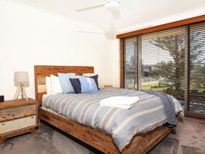 una camera con un letto e una grande finestra di Shores I Pet Friendly I 1 Min Walk to Beach a Culburra Beach