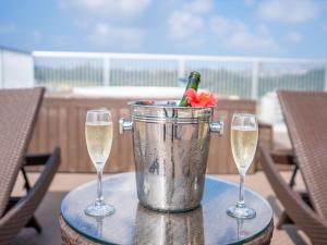 Um balde de champanhe e duas taças de vinho numa mesa. em Seaside Condominium Rana Chatan em Chatan