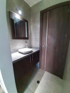 baño con lavabo y puerta de madera en DEPARTAMENTO TOTALMENTE NUEVO, AMOBLADO Y DE LUJO EN TONSUPA en Tonsupa
