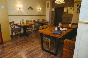 a restaurant with wooden tables and chairs in a room at Aurooms Kontinent Hotel in Novokuznetsk