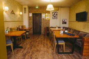 a restaurant with wooden tables and chairs and a couch at Aurooms Kontinent Hotel in Novokuznetsk