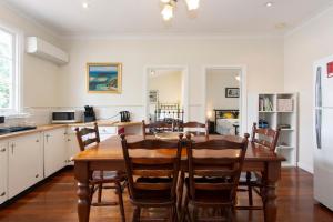 a kitchen and dining room with a wooden table and chairs at Cosy Cottage -3 Bedrooms Victoria Park in Perth
