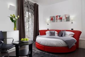 a bedroom with a red bed and a red chair at Gregorio VII Luxury Suites in Rome