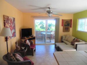 a living room with a couch and chairs and a television at Kehena Beach Getaway in Kehena