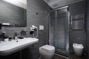 a bathroom with a sink and a toilet and a shower at Gregorio VII Luxury Suites in Rome