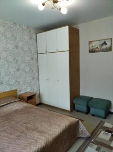 ベロクリハにあるApartment on Bratyev Zhdanovykhのベッドルーム1室(ベッド1台、キャビネット、椅子付)